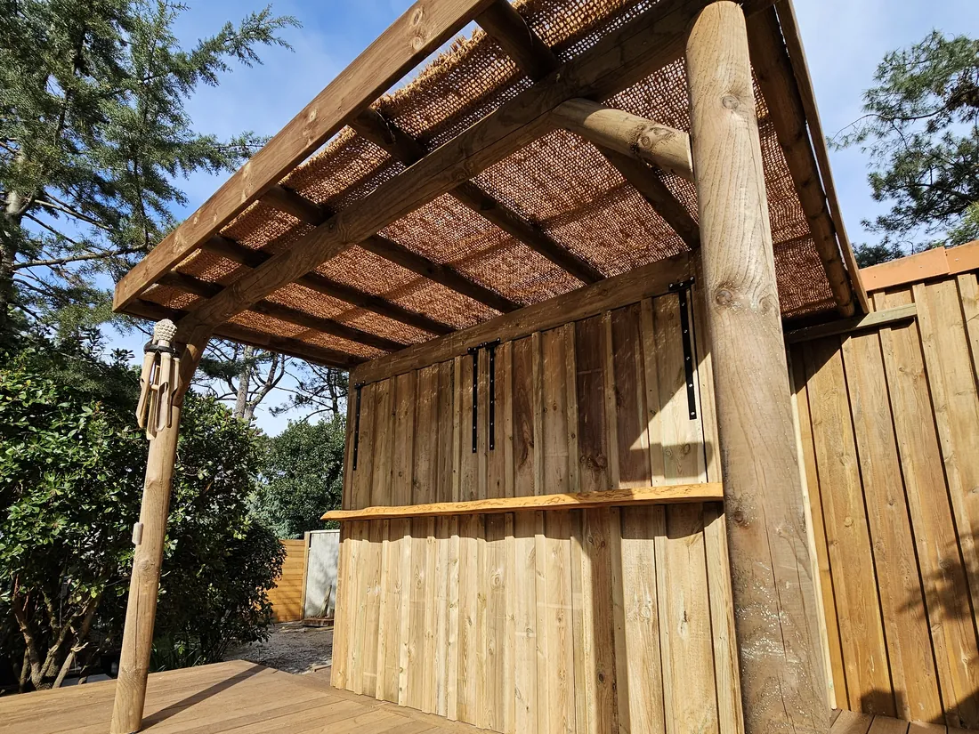 Carbet en bois à couverture de canisse, bardage vertical sur la face arrière