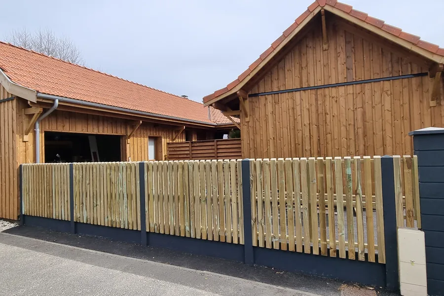Claustra bois vertical devant un bâtiment habillé d’un bardage bois
