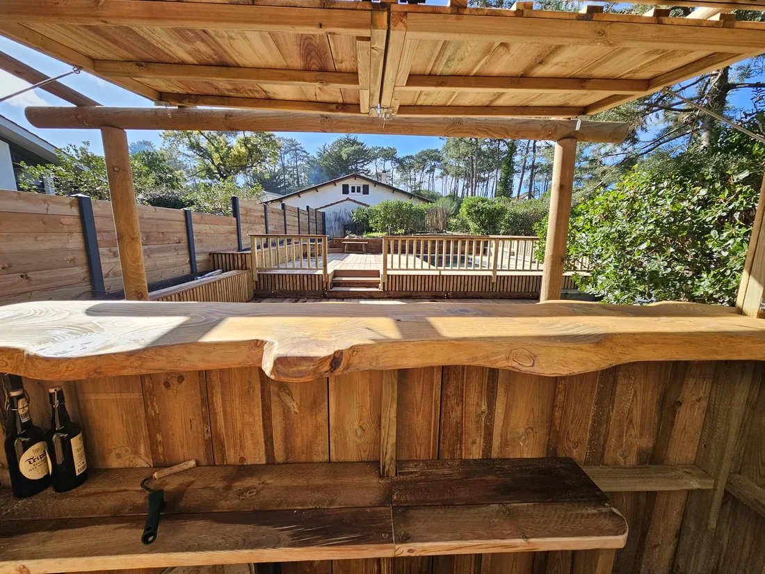 Comptoir en bois massif sous le carbet, vue sur la terrasse et la maison