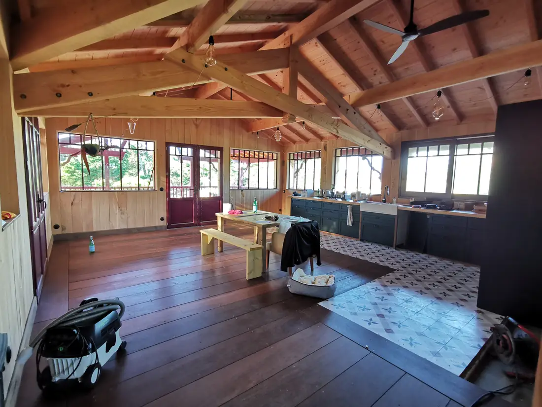 Grande salle ouverte sous une charpente bois apparente