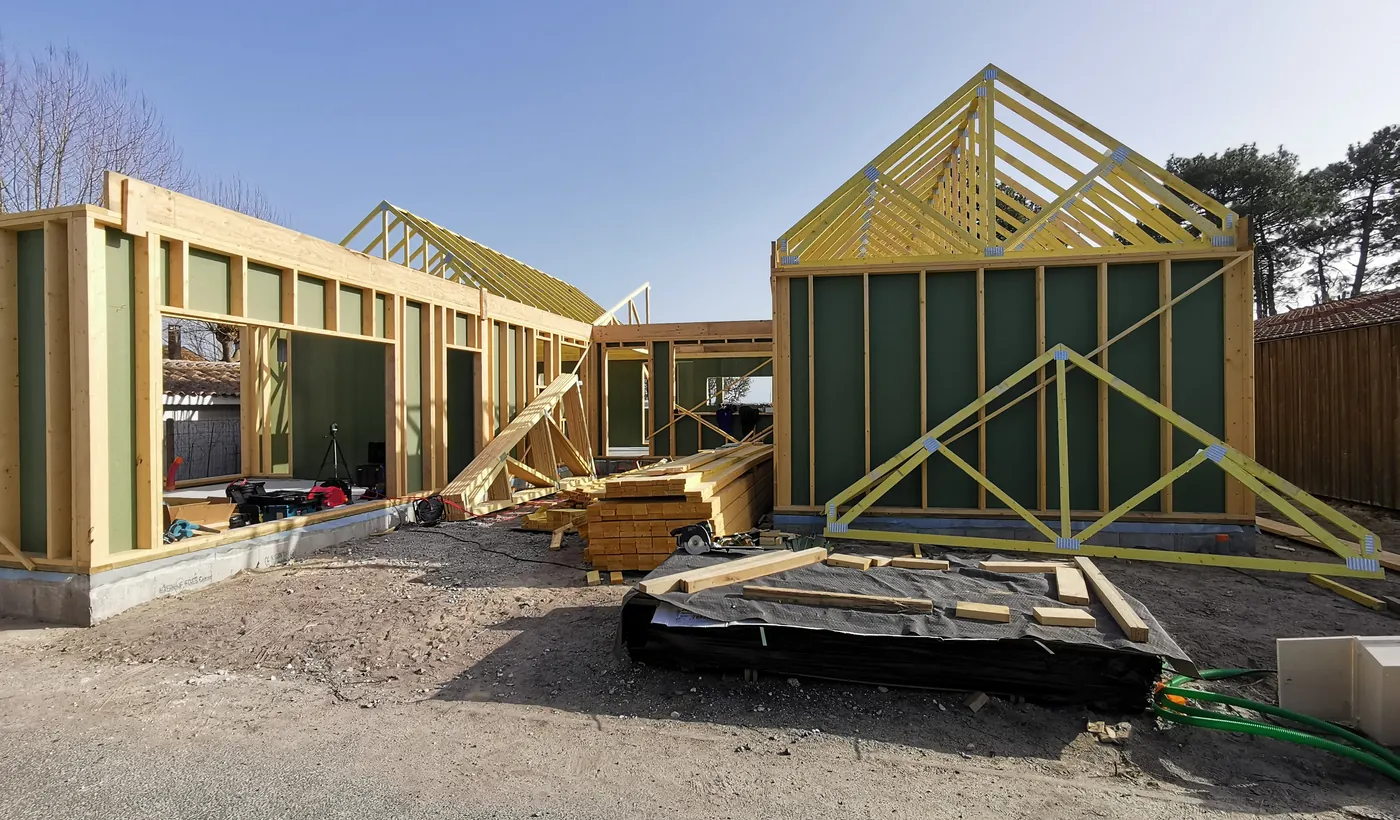 Ossature bois d’une maison montée sur sa dalle, pignons en place