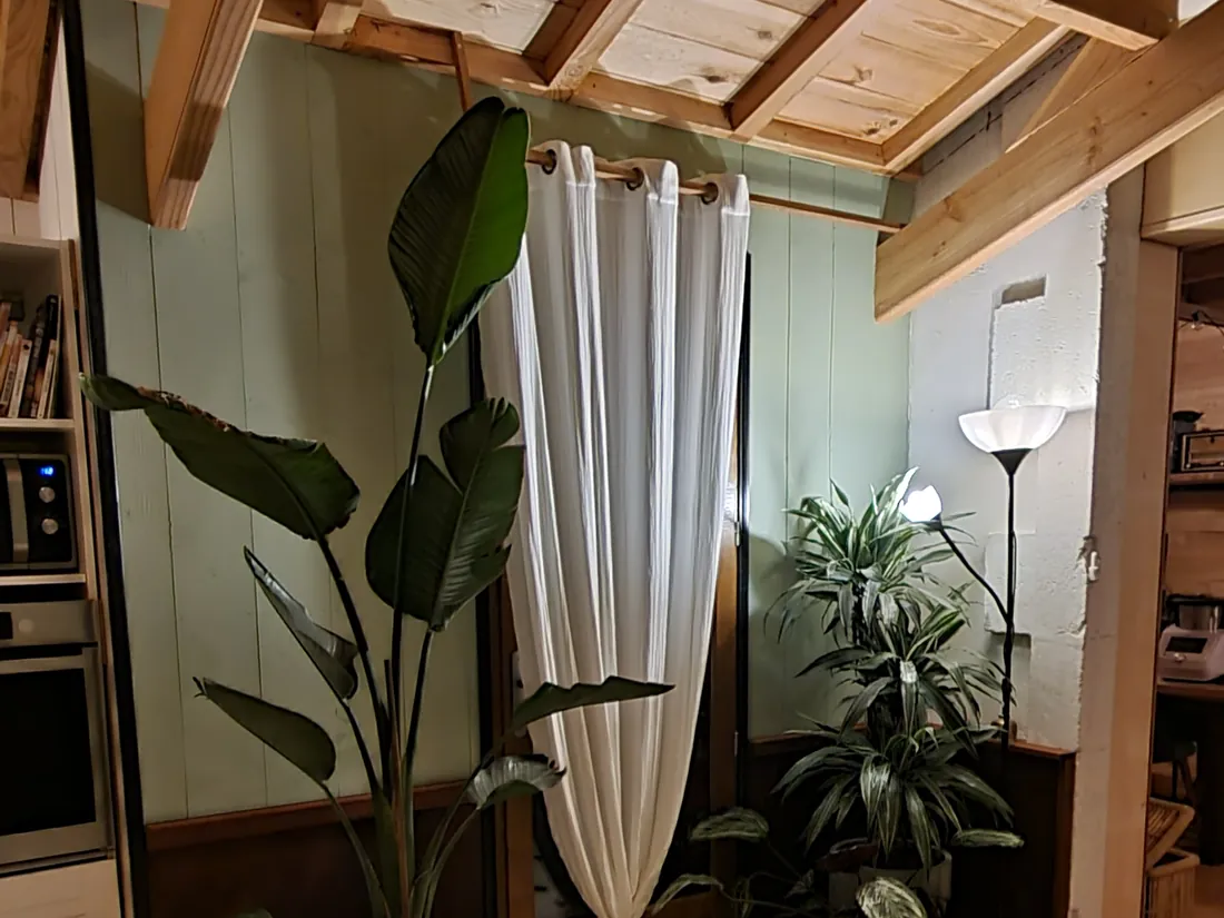 Pièce sous plafond en lames bois et poutres apparentes, carrelage à cabochons