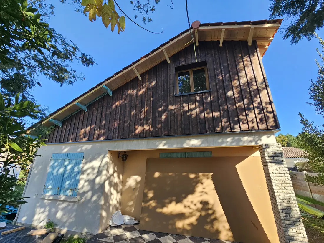 Surélévation à ossature bois habillée d’un bardage vertical, au-dessus d’un rez-de-chaussée enduit