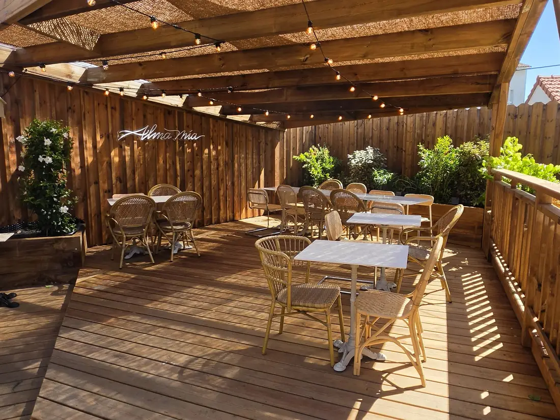 Terrasse couverte d’un restaurant, avec sa structure bois et son claustra