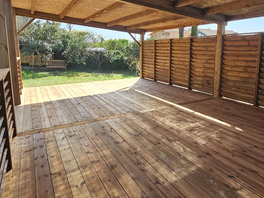 Terrasse couverte en plein soleil, lumière filtrée par la canisse